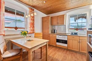 a kitchen with wooden cabinets and a wooden table at Ferienwohnung Gruber in Bodenwöhr +19 photos
