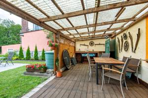 a wooden deck with a table and chairs and a pergola at Ferienwohnung Gruber in Bodenwöhr