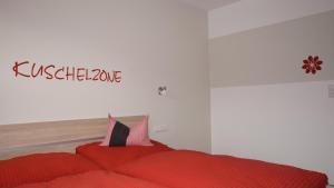 a bedroom with a red bed with a sign on the wall at Ferienwohnung Mario in Hippach