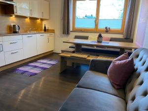 a living room with a couch and a table and a kitchen at Ferienwohnung Mario in Hippach