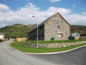 a stone building on the side of a road at Ty Talcen in Pennal