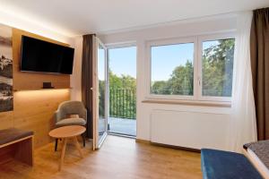 ein Wohnzimmer mit einer Glasschiebetür zu einem Balkon in der Unterkunft Kaiserchalet in Höchenschwand
