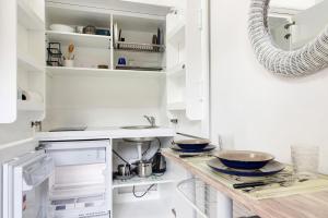 a kitchen with white cabinets and a counter with bowls at Margherita - Fronte Mare in Rapallo