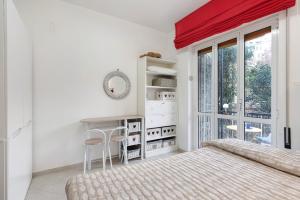 a bedroom with a bed and a desk and a window at Margherita - Fronte Mare in Rapallo