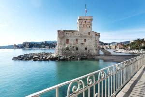 an old castle in the water next to a bridge at Margherita - Fronte Mare in Rapallo
