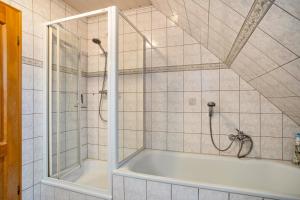 a bathroom with a bath tub and a shower at Ferienwohnung 'am Weidenring' in Pantelitz +14 photos