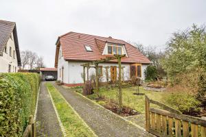 a house with a tree in the front yard at Ferienwohnung 'am Weidenring' in Pantelitz