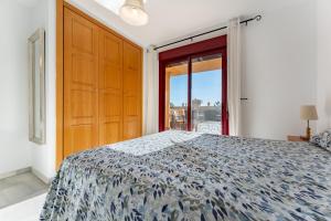 a bedroom with a bed and a large wooden door at 212 La Cala azul in La Cala de Mijas +17 photos
