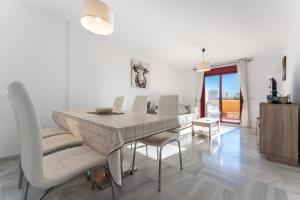 a dining room and living room with a table and chairs at 212 La Cala azul in La Cala de Mijas