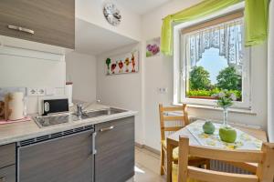 a kitchen with a table and a sink and a window at Ferienwohnung Marks - Hohnstein in Rathewalde