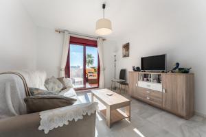 a living room with a couch and a tv at 212 La Cala azul in La Cala de Mijas