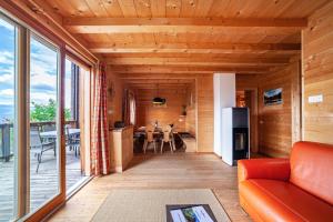 a living room with a red couch and a kitchen at Bergchalet Refugium Martius in Marlengo