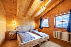 a bedroom with a bed in a wooden room at Bergchalet Refugium Martius in Marlengo