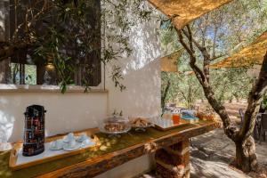 a table with food on it next to a tree at Domus mea salento Arazzo Rosso in Ugento