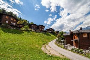 a dirt road next to houses on a hill at Bergchalet Refugium Martius in Marlengo