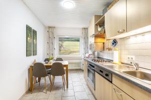 a kitchen with a table and chairs and a sink at Ferienwohnung Kebben in Kirchhundem