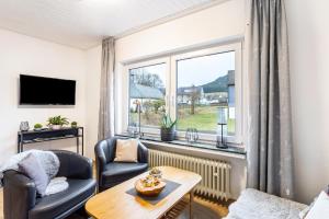 a living room with a couch and a table and a window at Ferienwohnung Kebben in Kirchhundem
