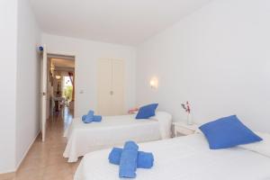 two beds in a room with blue pillows on them at Lurdes in Ciutadella +17 photos