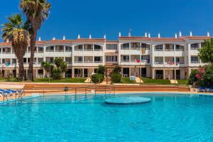 a large swimming pool in front of a large building at Lurdes in Ciutadella