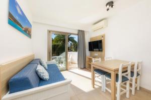 a living room with a dining room table and a bedroom at Apartamento Bon Aire N3 in Cala Ferrera