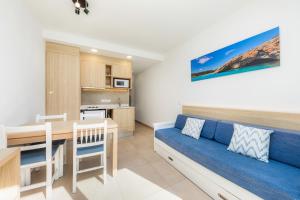 a living room with a blue couch and a table at Apartamento Bon Aire N3 in Cala Ferrera