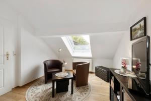 a living room with a table and chairs and a tv at Ferienwohnung in Potsdam in Potsdam