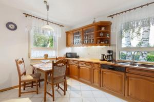 a kitchen with wooden cabinets and a table and chairs at Ferienwohnung in Potsdam in Potsdam