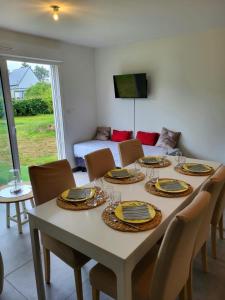 a dining room with a table with chairs and a couch at Gîte Bord De Mer La Guichardière in Pirou