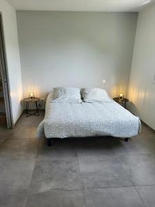 a bed in a room with two side tables at Gîte Bord De Mer La Guichardière in Pirou