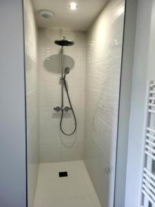 a shower with a shower head in a bathroom at Gîte Bord De Mer La Guichardière in Pirou +18 photos