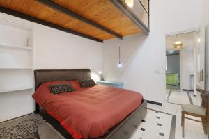 a bedroom with a bed with a red comforter at Casa Meloria in Finale Ligure