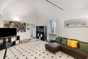 a living room with a couch and a tv at Casa Meloria in Finale Ligure
