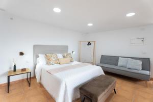 a white bedroom with a bed and a couch at Casa Los Pinos in Chinamada