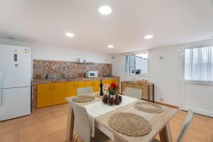 a kitchen with a table and a kitchen with yellow cabinets at Casa Los Pinos in Chinamada