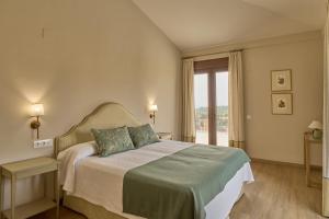a bedroom with a bed and a large window at Dehesa El Alcornocal in Posadas