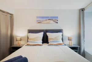 a bedroom with a large bed with two lamps at Le Douar Armor - cour intérieure in Dinan
