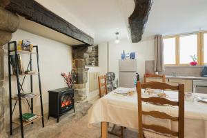 a living room with a table and a stove at Le Douar Armor - cour intérieure in Dinan +18 photos