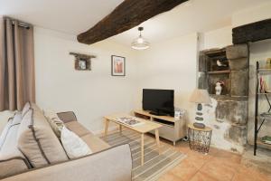 a living room with a couch and a tv at Le Douar Armor - cour intérieure in Dinan