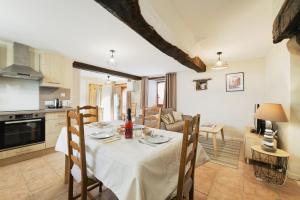 a kitchen and dining room with a table and chairs at Le Douar Armor - cour intérieure in Dinan