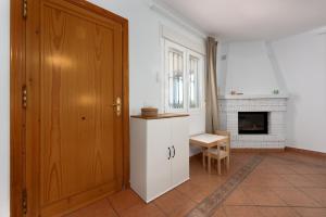 a kitchen with a wooden door and a fireplace at Casa con piscina La Madriguera in Estepona