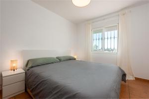 a white bedroom with a bed and a window at Casa con piscina La Madriguera in Estepona +22 photos