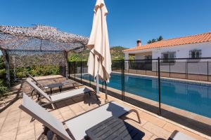 a patio with a umbrella and a swimming pool at Casa con piscina La Madriguera in Estepona