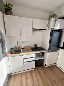 a small kitchen with white cabinets and a sink at Schmuckkästle in Sasbachwalden