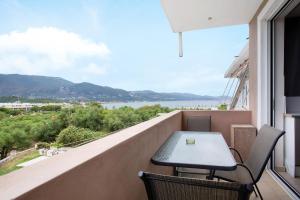 a table and chairs on a balcony with a view of the water at Villa Dionysia Studio 10 in Alikanas