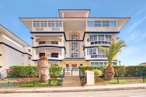 an apartment building with palm trees in front of it at Parque Mar V in La Mata