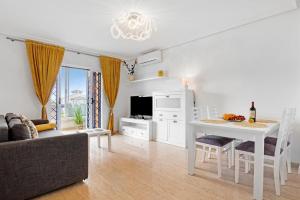 a living room with a white table and a kitchen at Parque Mar V in La Mata