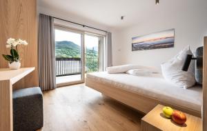 a hotel room with a bed and a large window at Gostnerhof Barbian in Barbiano +54 photos