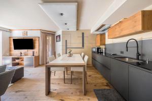 a kitchen with a table and a sink at Residence Latemarblick in Nova Levante +17 photos