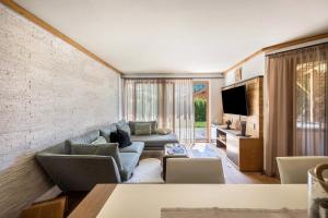 a living room with a couch and a tv at Residence Latemarblick in Nova Levante
