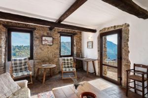 a living room with windows and a table and chairs at The Gallery - Unità 16 in Baiardo